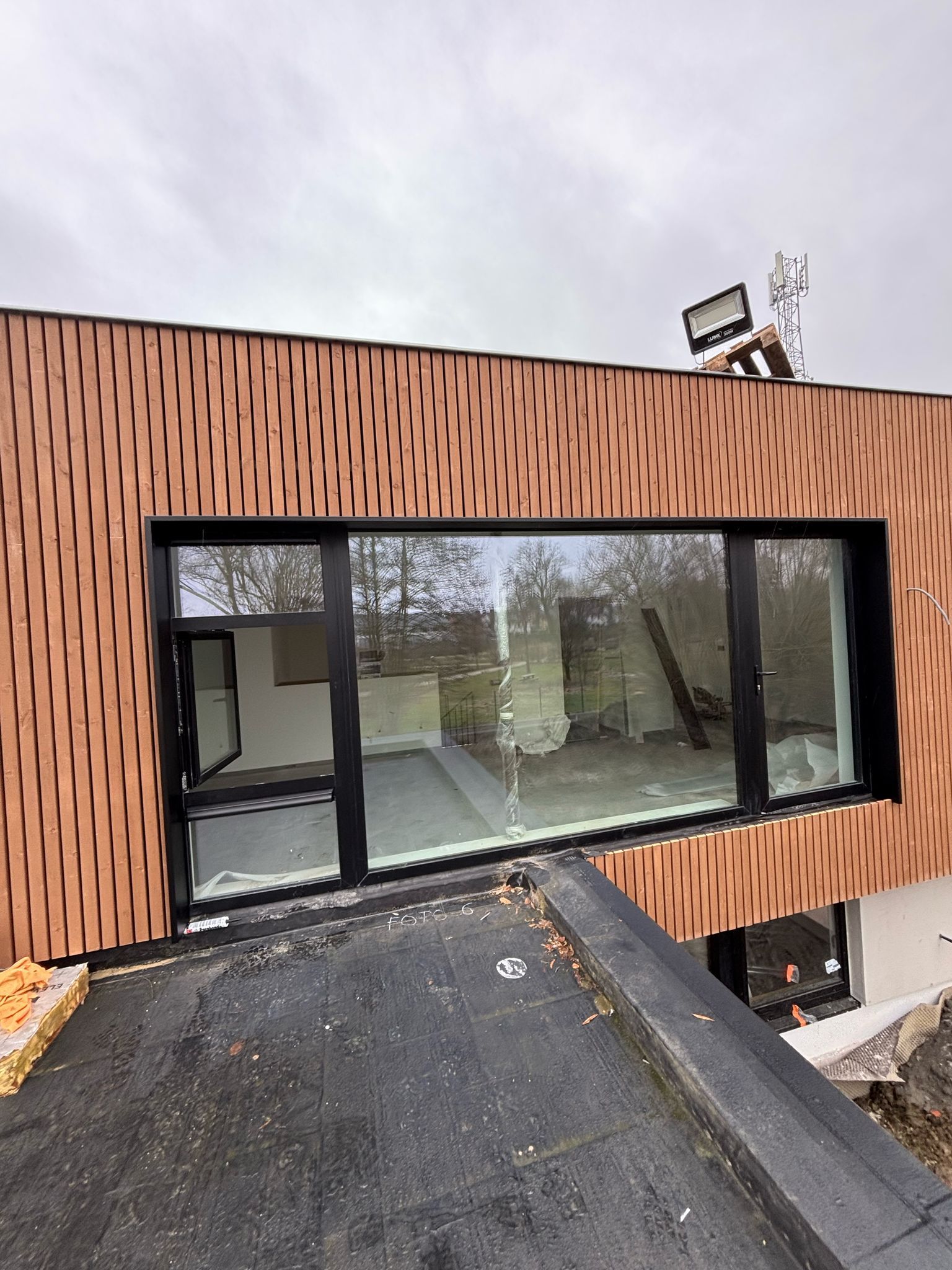 Volume en bardage bois et grande baie fixe et ouvrante, chantier en finition