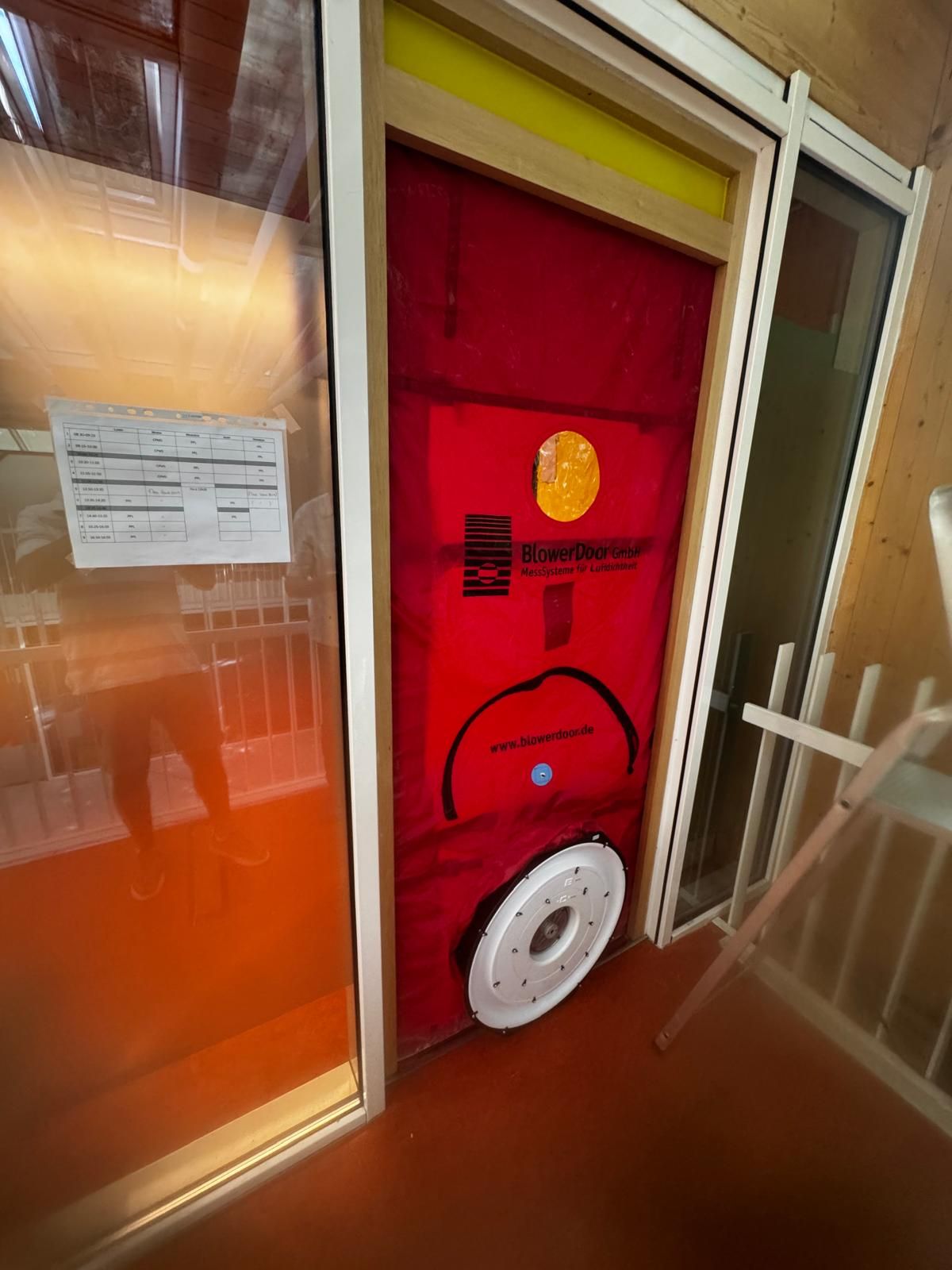 Porte soufflante BlowerDoor installée dans un cadre de porte, vue intérieure aux tons chauds